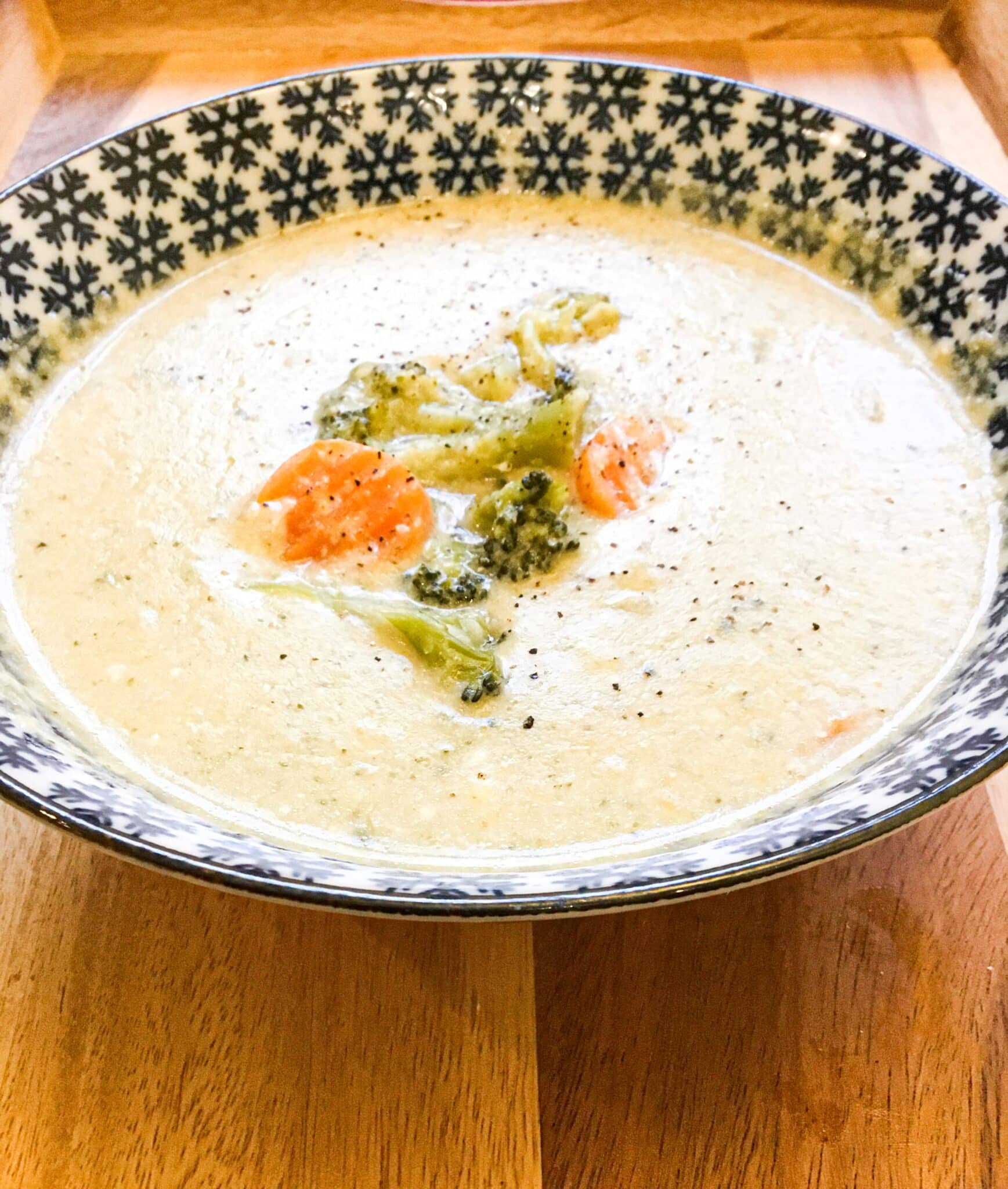 Vegetarian broccoli yogurt soup (easy, creamy, & healthy) recipe is ready and served on a dark blue color printed bowl.