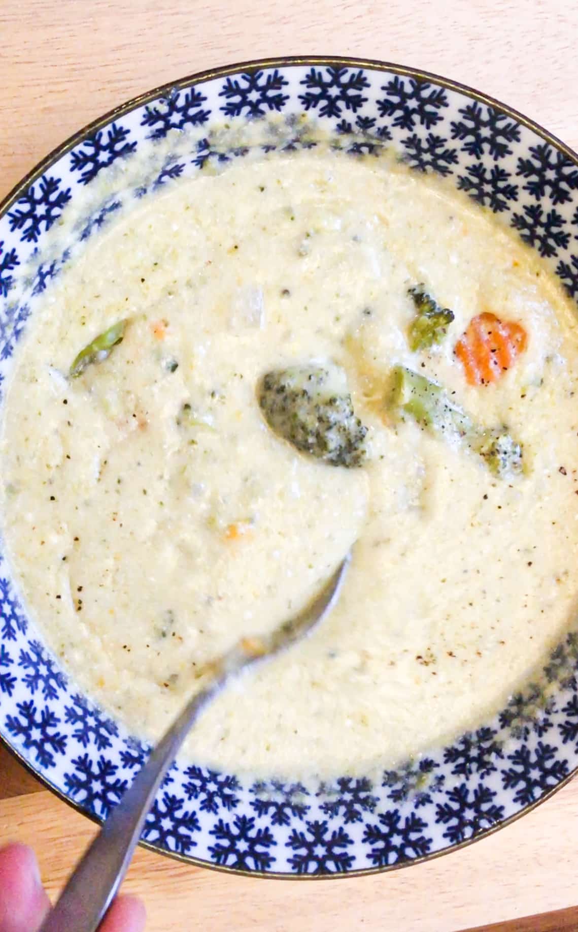 vegetarian broccoli cheddar soup  is served and being eaten.