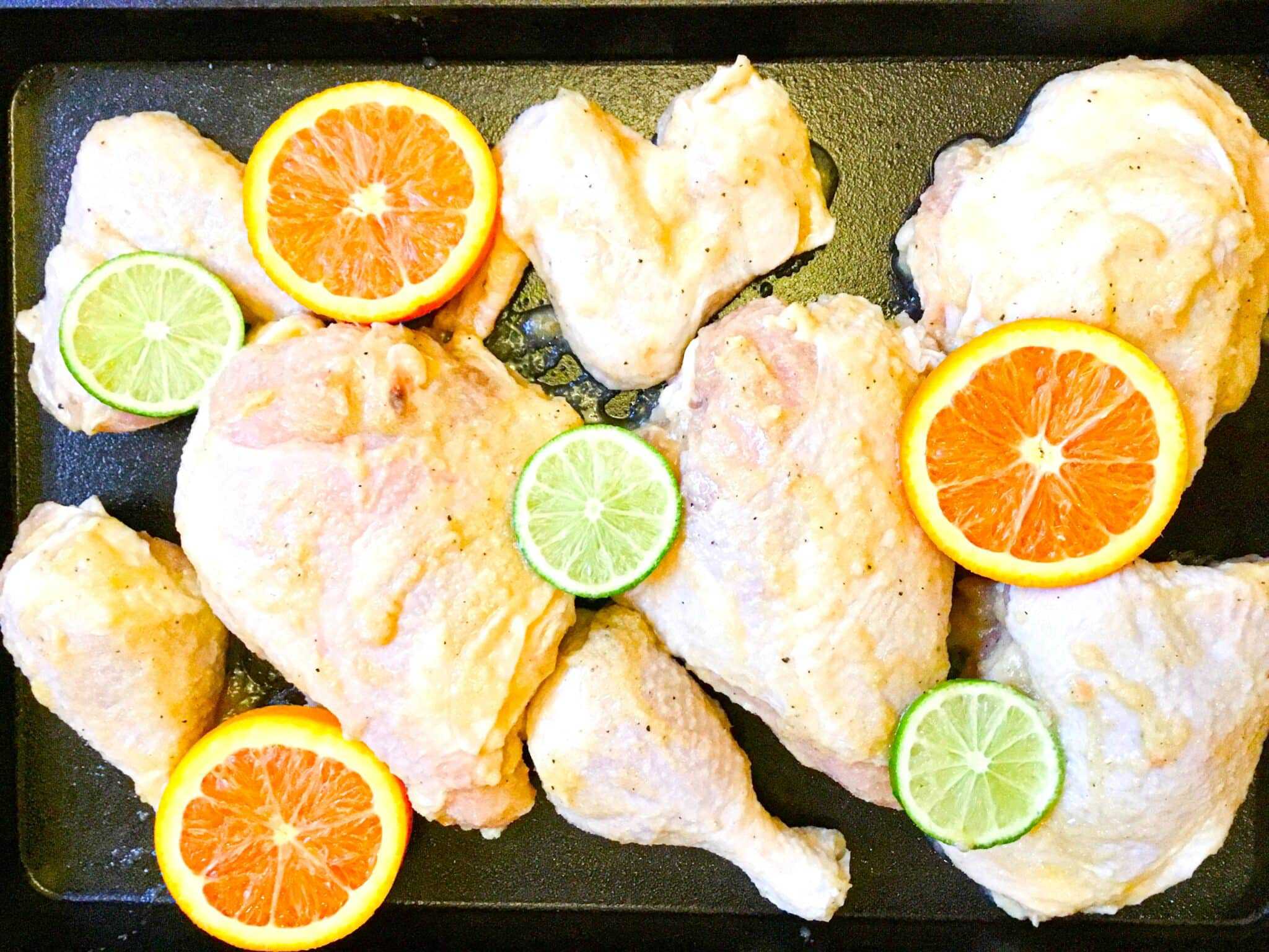 whole chicken cut in 8 pieces sweet and sour chicken marinated in lime and orange juice on a sheet pan ready to bake