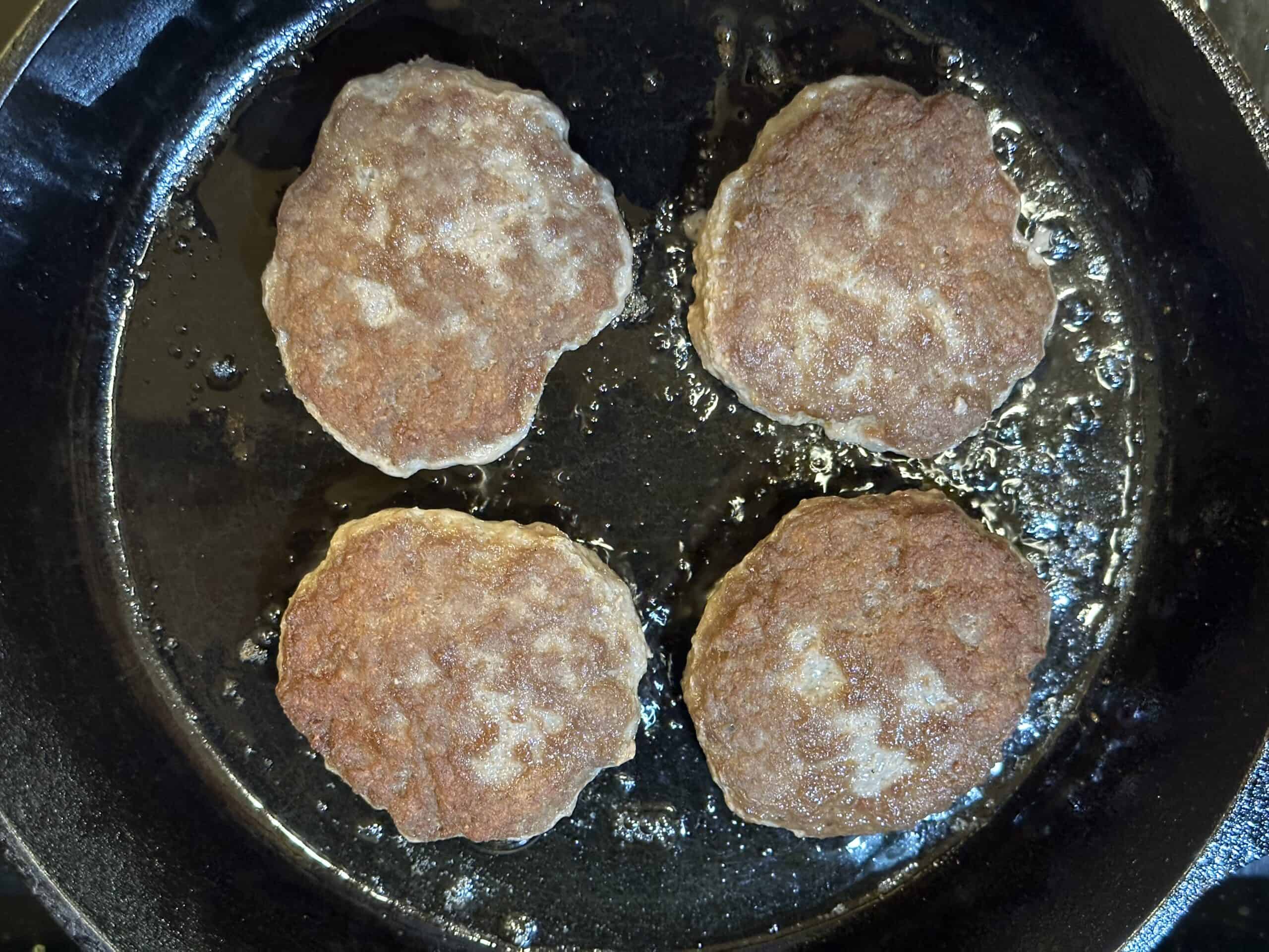 Patties are flipped for the other side to cook.
