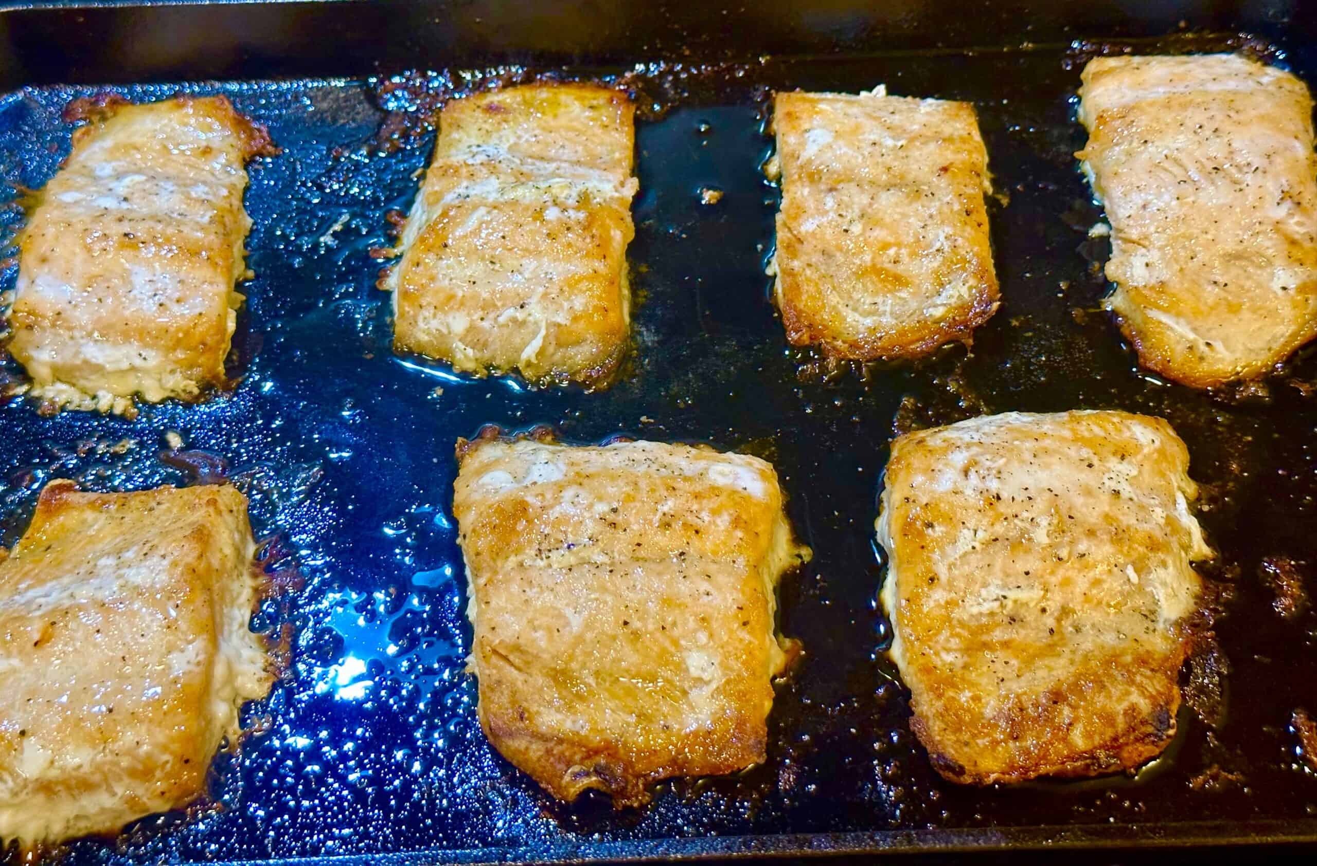 baked 7 frozen salmon fillets on a cast iron sheet pan ready to serve! 