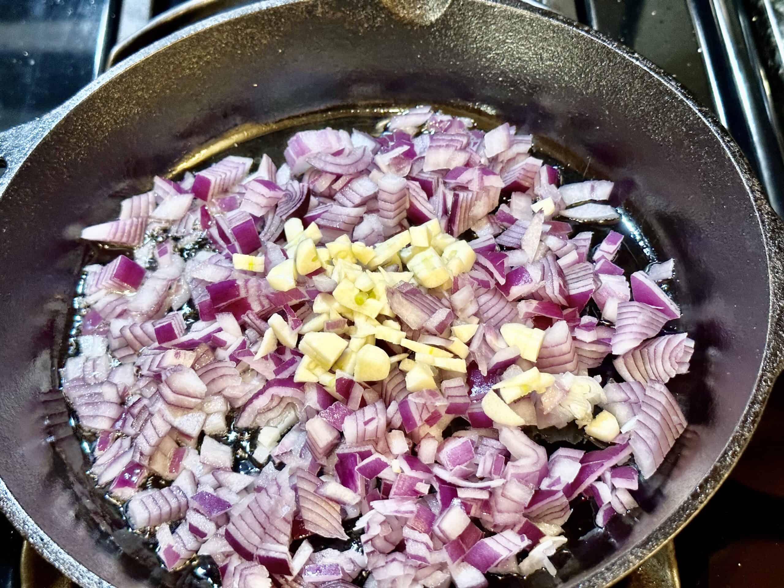 Diced onion and garlic on a hot skillet