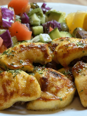 Juicy oven grilled chicken breast served with fresh salad.