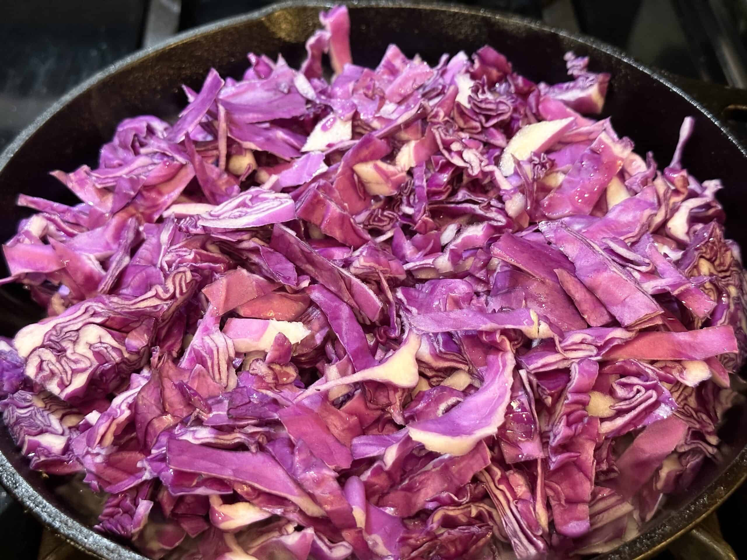 chopped red cabbage is added to the skillet.