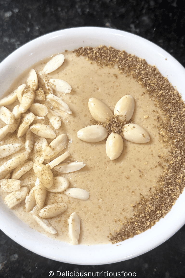 Pakistani kheer recipe is served in a white bowl and garnished with almond and grounded flax seeds.