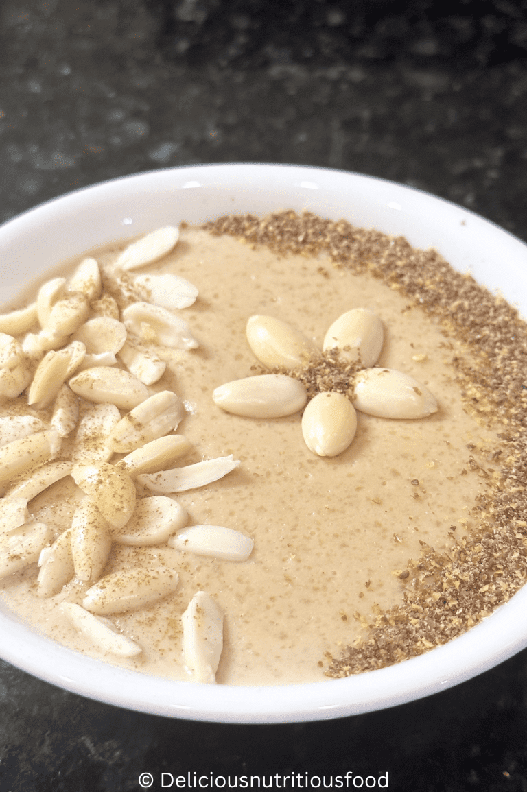Pakistani kheer recipe is served in a white bowl and garnished with almond and grounded flax seeds.