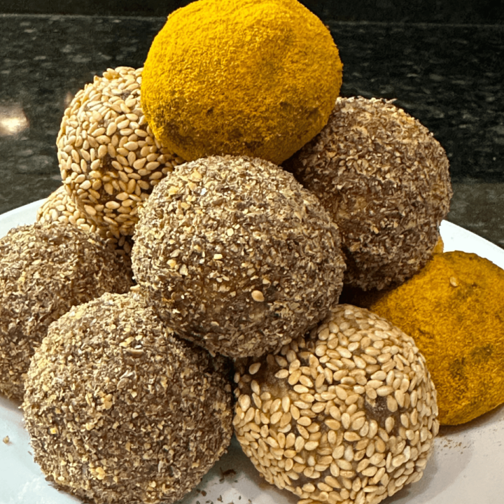 12 turmeric energy balls served on a white plate.