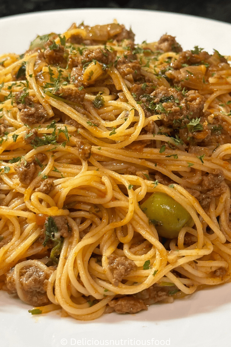 angel hair pasta with ground beef is served on a white plate.