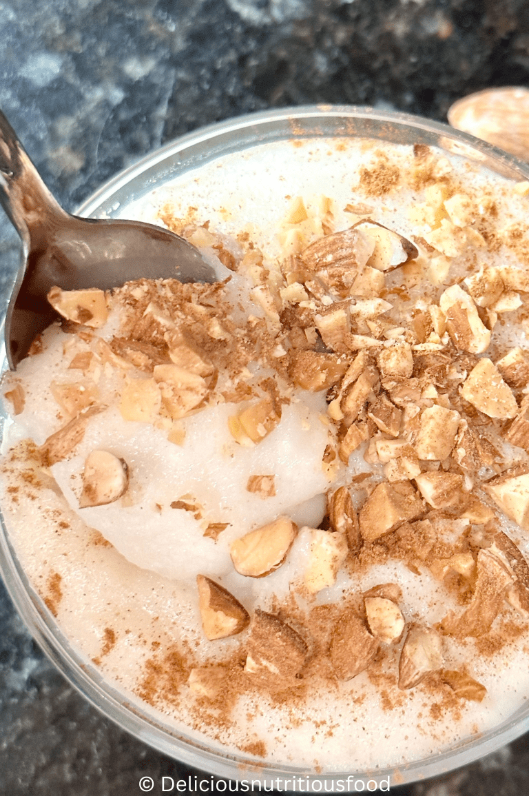 Muhallebi- Middle Eastern milk pudding is served. A close up image of a spoon full of the pudding.