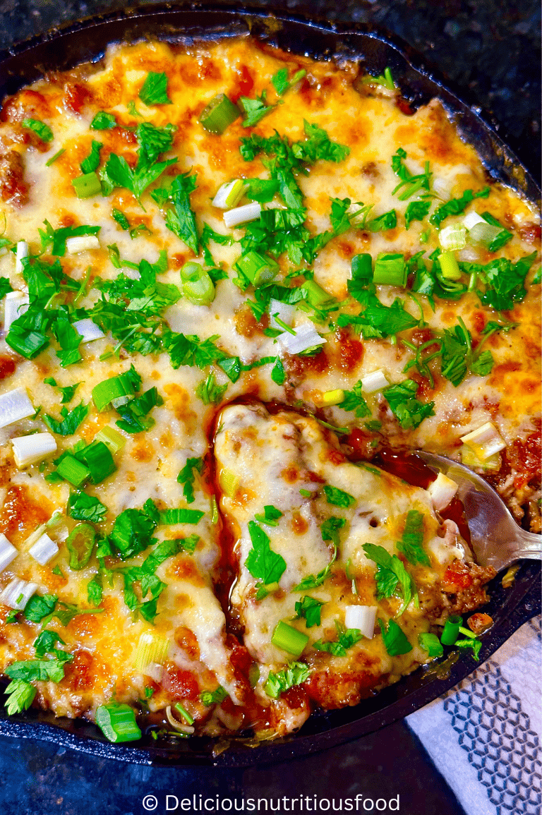 keto eggplant pizza casserole with ground beef is scoped with a spoon.